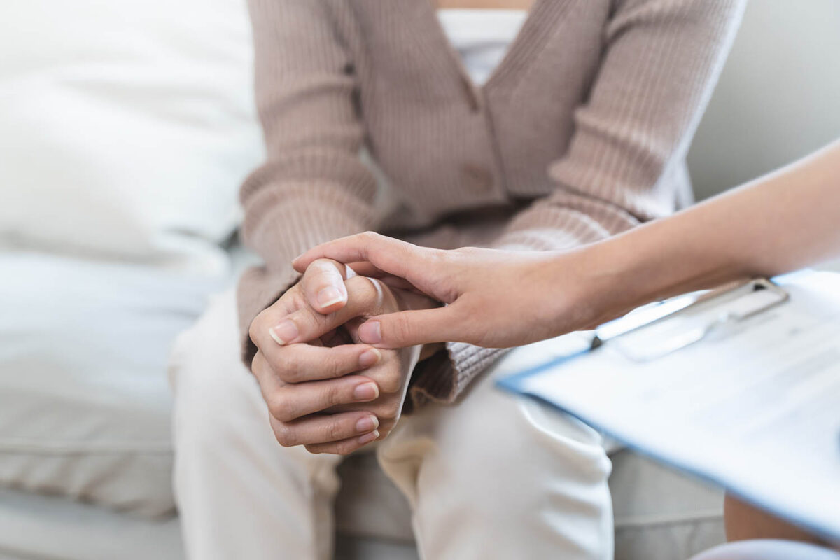 psychologist touching hands and encouraging stressed woman have