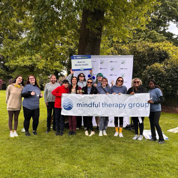 Mindful Therapy Group staff hold up a company banner at the NAMI Walk for Mental Health