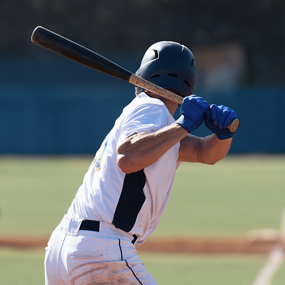 Person ready to swing with a baseball bat on a baseball field