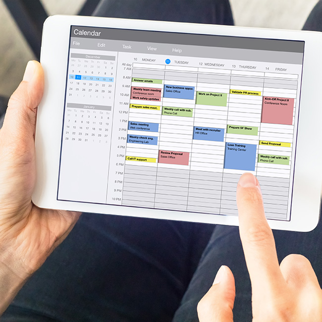 A person navigates a calendar on a tablet
