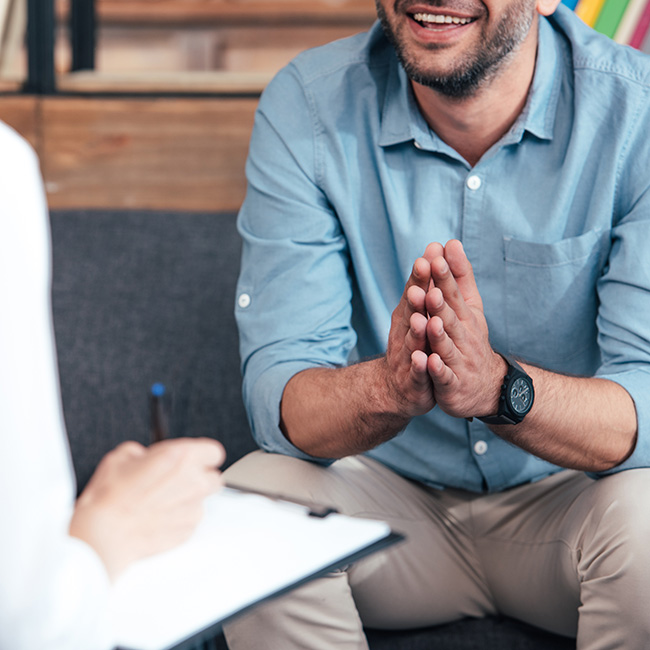 A provider meets with a client, taking notes on a notepad