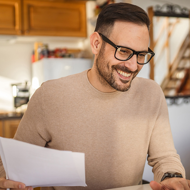 A man organizes documents with a smile on his face