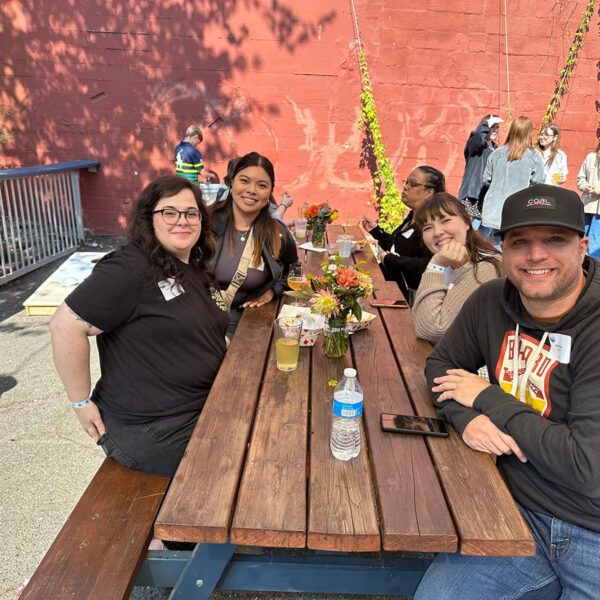 Mindful Support Services operations team celebrates on a sunny day on the patio of a brewery