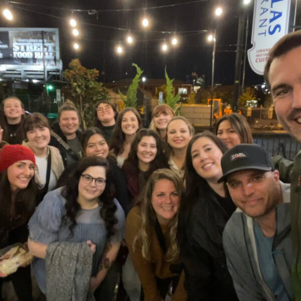 Mindful Support Services leadership group photo, nighttime, outside of a restaurant