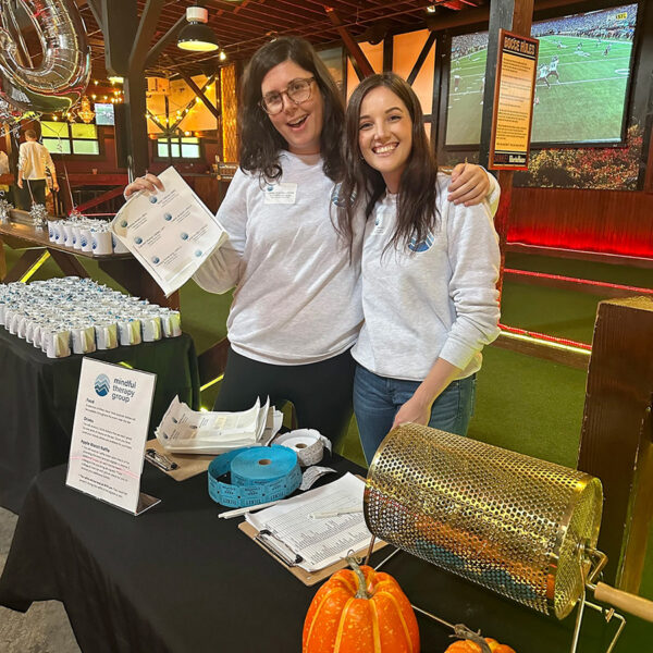 Mindful Support Services leaders Lauren Bratney and Tessa Smith run the raffle booth at a provider event