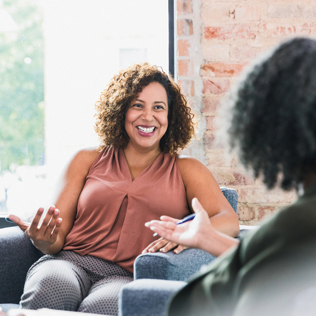 A client smiles while in a therapy session in a bright room