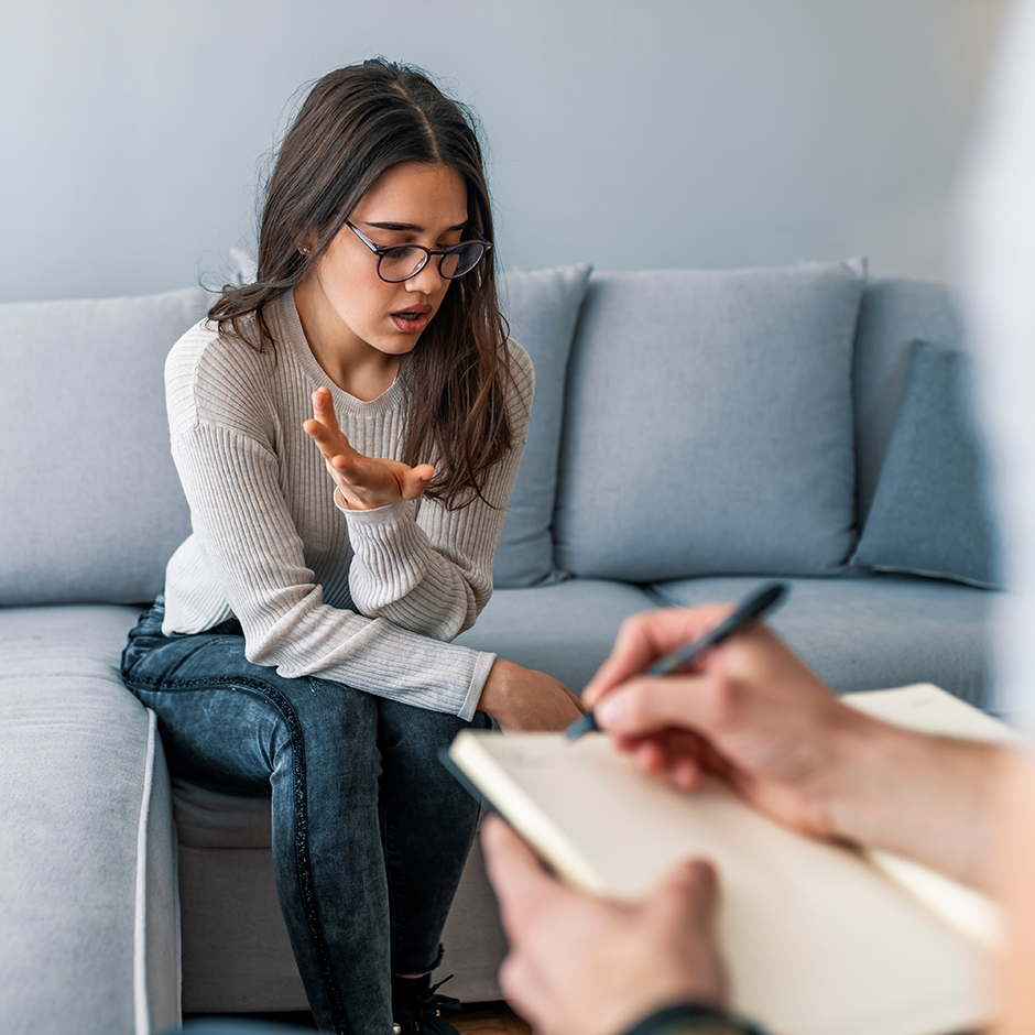 Psychologist listening to woman in trouble during therapy session.